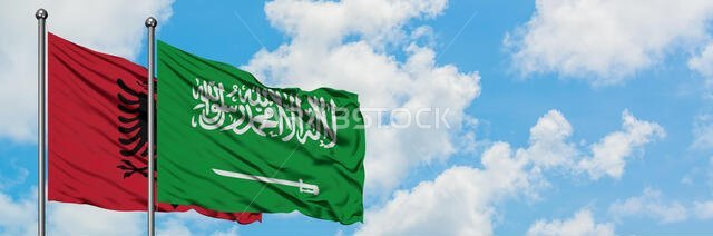 Albania and Saudi Arabia flag waving in the wind against white cloudy blue sky together. Diplomacy concept, international relations.