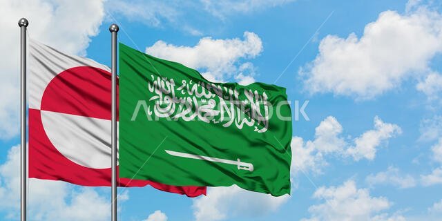 يرفرف علم غرينلاند وعلم المملكة العربية السعودية معاً في مهب الريح أمام سماء زرقاء صافية تتخللها غيوم بيضاء. مفهوم الدبلوماسية، العلاقات الدولية.