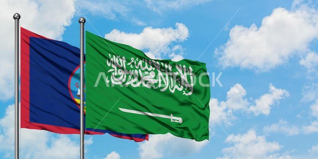 Guam and Saudi Arabia flag waving in the wind against white cloudy blue sky together. Diplomacy concept, international relations.