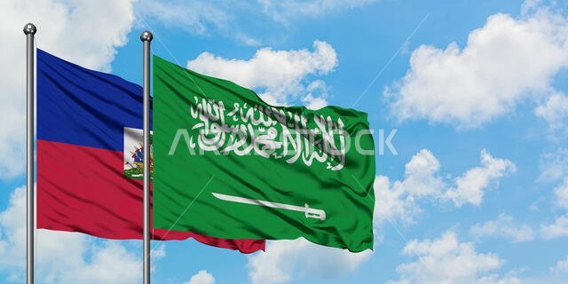 يرفرف علم هايتي وعلم المملكة العربية السعودية معاً في مهب الريح أمام سماء زرقاء ملبدة بالغيوم البيضاء. مفهوم الدبلوماسية، العلاقات الدولية.