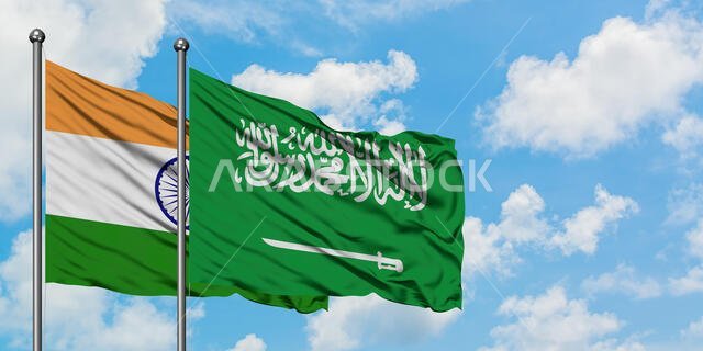 يرفرف علم الهند والسعودية معاً في مهب الريح أمام سماء زرقاء صافية تتلألأ بالغيوم البيضاء. مفهوم الدبلوماسية، العلاقات الدولية.