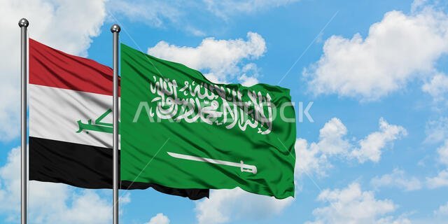 يرفرف علم العراق والسعودية معاً في مهب الريح أمام سماء زرقاء صافية تتلألأ بالغيوم البيضاء. مفهوم الدبلوماسية، العلاقات الدولية.