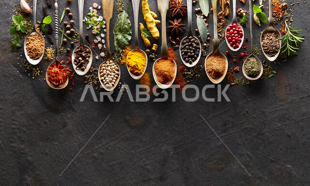 صورة مقربة لمجموعة من التوابل والأعشاب على طاولة الجرافيت ، توابل خشنة وناعمة ، بهارات