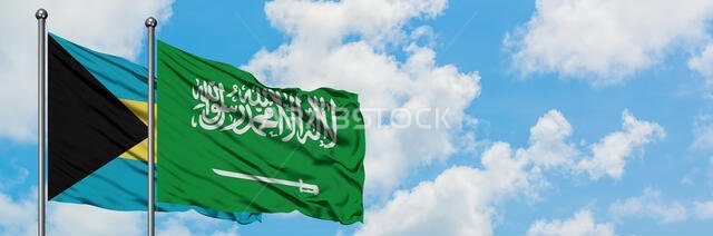 Bahamas and Saudi Arabia flag waving in the wind against white cloudy blue sky together. Diplomacy concept, international relations.