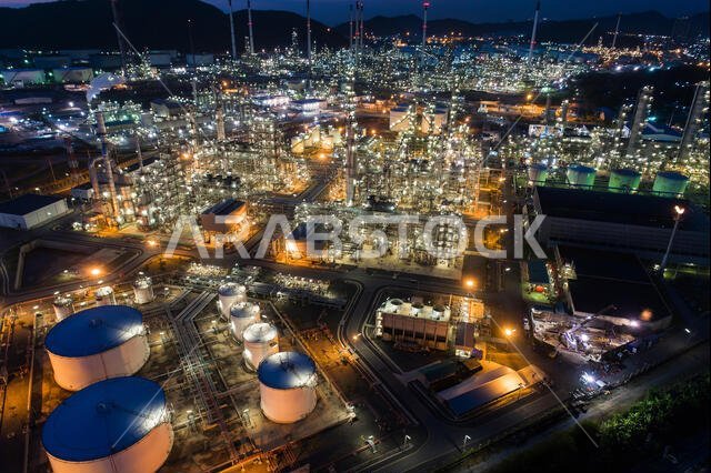 Aerial view oil storage tank with oil refinery factory industrial. Oil refinery plant at night. industry factory concept and transportation.
