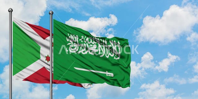 يرفرف علم بوروندي وعلم المملكة العربية السعودية معاً في مهب الريح أمام سماء زرقاء صافية تتخللها غيوم بيضاء. مفهوم الدبلوماسية، العلاقات الدولية.