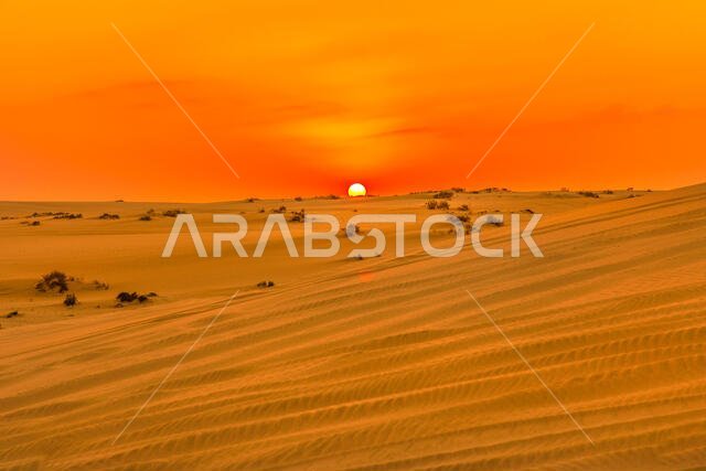 ألوان غروب الشمس الحمراء والبرتقالية فوق الكثبان الرملية في البحر الداخلي. منظر صحراوي قرب قطر والمملكة العربية السعودية. خور العديد، الخليج العربي، الشرق الأوسط