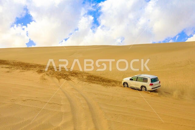 خور العديد، قطر - 19 فبراير 2019: مغامرة على الطرق الوعرة بسيارة تويوتا لاند كروزر في الصحراء العربية. سيارة دفع رباعي تجتاز الكثبان الرملية في البحر الداخلي