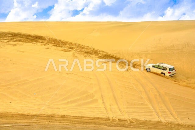 خور العديد، قطر - 19 فبراير 2019: مغامرة على الطرق الوعرة بسيارة تويوتا لاند كروزر في الصحراء العربية. سيارة دفع رباعي تجتاز الكثبان الرملية في البحر الداخلي