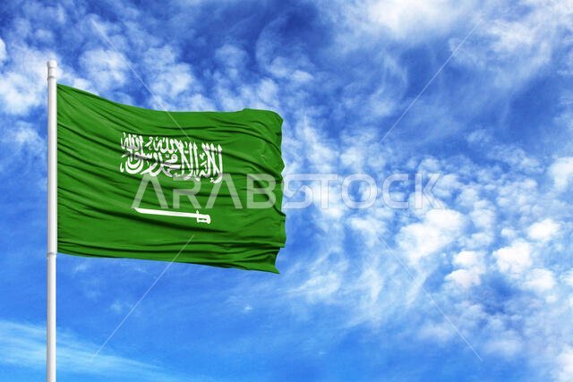 National flag of Saudi Arabia on a flagpole in front of blue sky