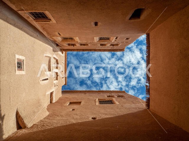 طراز معماري عربي، عمارة طينية، سماء فوق بلدة ريفية، ورق جدران فني للنوافذ، صورة عطلة.