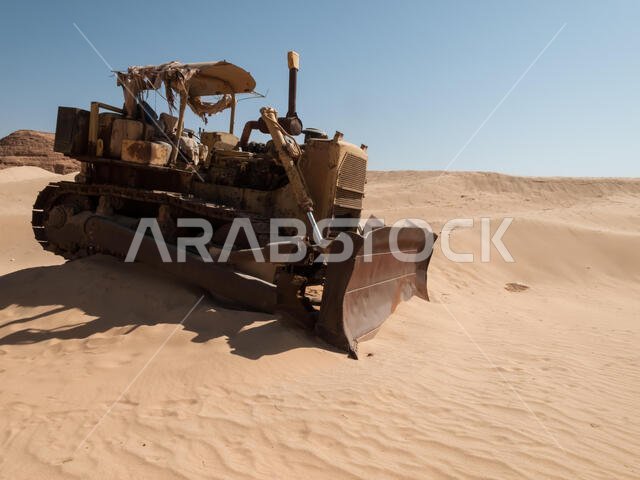 An old bulldozer abandoned in the middle of the desert in Saudi Arabia. Construction machinery