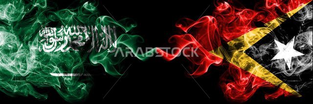 Saudi Arabia Kingdom vs East Timor smoky mystic flags placed side by side. Thick colored silky smoke flags of Arabic, Arabian and East Timor