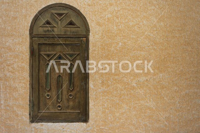 Wooden window in the Arab style on the background of textured wall