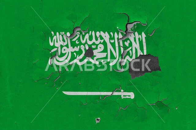 Close up grungy, damaged and weathered Saudi Arabia flag on wall peeling off paint to see inside surface.