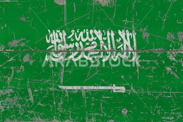 Grunge Saudi Arabia flag on old scratched wooden surface. National vintage background.
