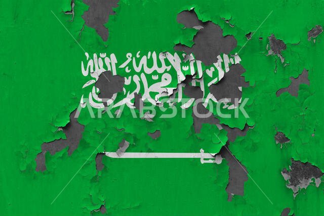 Close up grungy, damaged and weathered Saudi Arabia flag on wall peeling off paint to see inside surface.