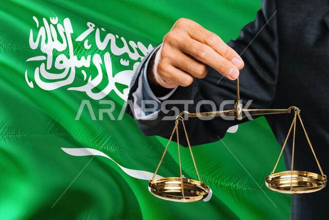 Saudi Judge is holding golden scales of justice with Saudi Arabia waving flag background. Equality theme and legal concept. Saudi Judge is holding golden scales of justice with Saudi Arabia waving flag background. Equality theme and legal concept.