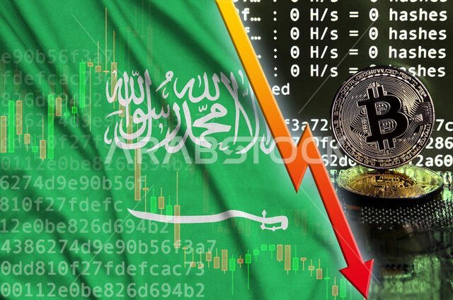 علم المملكة العربية السعودية وسهم أحمر ساقط على شاشة تعدين البيتكوين، بالإضافة إلى عملتين ذهبيتين من البيتكوين. مفهوم انخفاض معدل التحويل في تعدين العملات المشفرة.