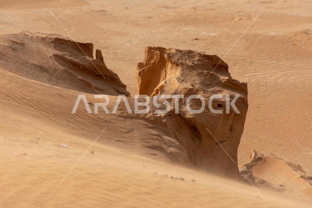 الكثبان الرملية مع الرمال المتطايرة على الأرض أثناء عاصفة رملية.