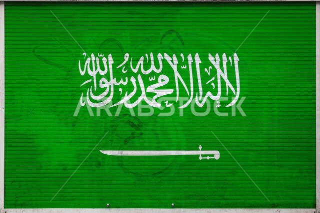 صورة مقرّبة لجدار معدني قديم عليه علم المملكة العربية السعودية. مفهوم الاستيراد والتصدير وتخزين البضائع وتوزيعها داخل المملكة.