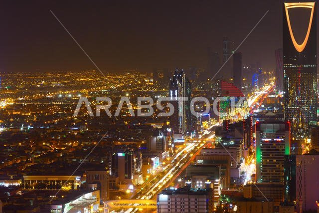 منظر بانورامي لأفق مدينة الرياض ليلاً، مع مركز المملكة في الخلفية والإضاءة الصفراء، عاصمة المملكة العربية السعودية