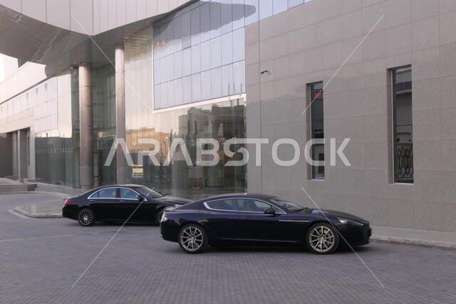 RIYADH, SAUDI ARABIA - DECEMBER 18, 2018: Two luxury cars, parked at a modern building in the city of Riyadh