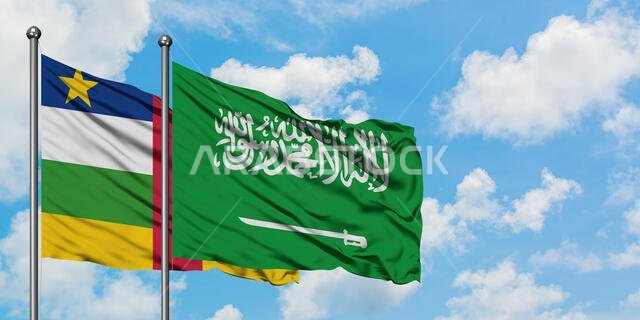 يرفرف علم جمهورية أفريقيا الوسطى وعلم المملكة العربية السعودية معاً في مهب الريح أمام سماء زرقاء ملبدة بالغيوم البيضاء. مفهوم الدبلوماسية، العلاقات الدولية.