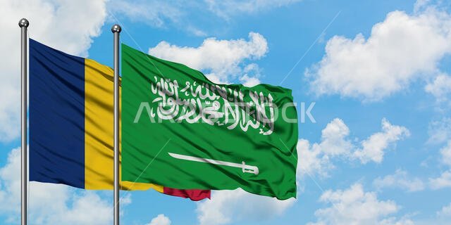 يرفرف علما تشاد والسعودية معاً في مهب الريح أمام سماء زرقاء ملبدة بالغيوم البيضاء. مفهوم الدبلوماسية، العلاقات الدولية.