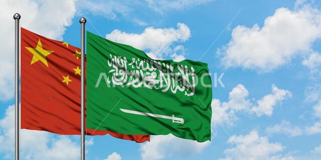 يرفرف علم الصين والسعودية معاً في مهب الريح أمام سماء زرقاء صافية تتلألأ بالغيوم البيضاء. مفهوم الدبلوماسية، العلاقات الدولية.