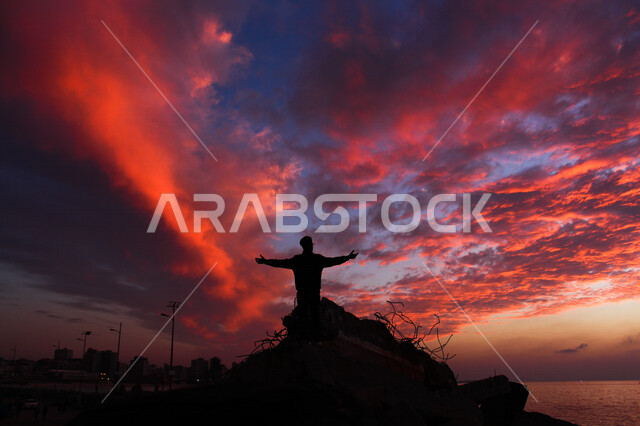 silhouette from back of man standing on rocks at sunset scenic nature sea beach beauty sky sunset nature background