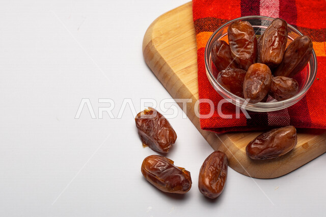 صورة مقربة لطبق من تمر السكري الصحي، وجبة ذات قيمة غذائية عالية، ضيافة رمضانية، انواع من التمور الصحية واللذيذة، خلفية بيضاء