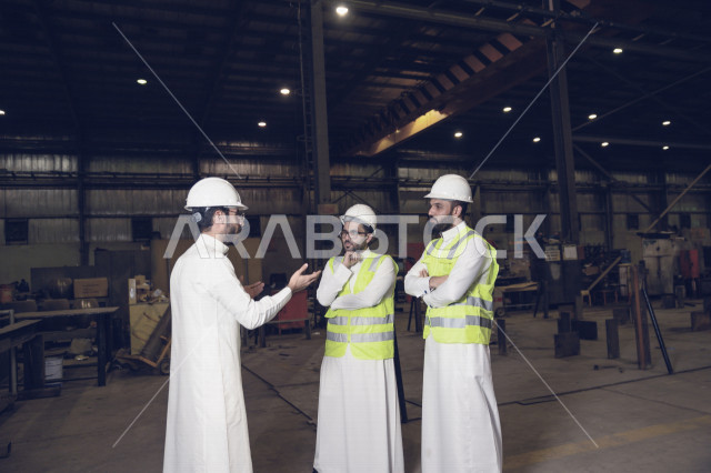اجتماع مجموعة من المهندسين السعوديين داخل مصنع الحديد ، التحقق من جودة المصنع، تطوير آلية الانتاج ، ارتداء خوذة و سترة الحماية الخاصة بالعمل