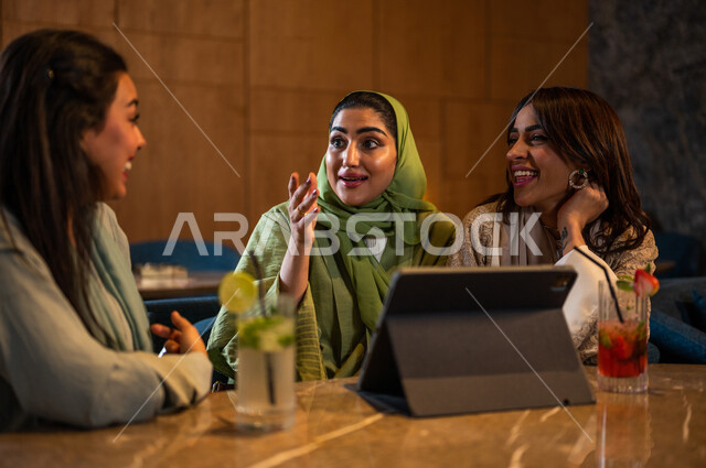 صديقات عربيات خليجيات سعوديات يجلسن في المقهى، إستخدام جهاز التابلت، التسوق الالكتروني، علاقات إجتماعية بين الإصدقاء، إستخدام وسائل التواصل الإجتماعي، قضاء أوقات ممتعة مع الأصدقاء، تصفح الإنترنت، جلسة وناسة وتعارف، كوفي شوب راقي بالسعودية