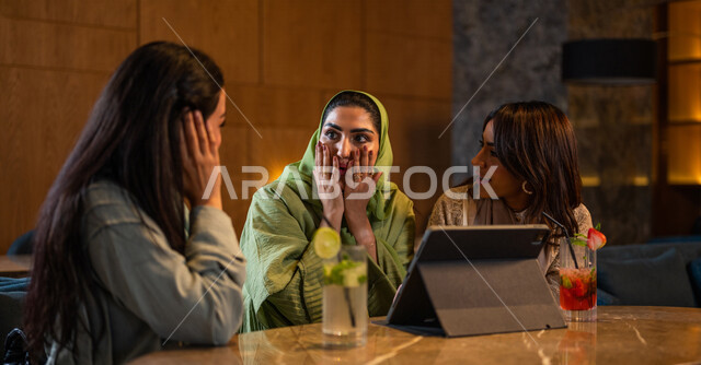 صديقات عربيات خليجيات سعوديات يجلسن في المقهى، إستخدام جهاز التابلت، التسوق الالكتروني، علاقات إجتماعية بين الإصدقاء، إستخدام وسائل التواصل الإجتماعي، قضاء أوقات ممتعة مع الأصدقاء، تصفح الإنترنت، جلسة وناسة وتعارف، كوفي شوب راقي بالسعودية