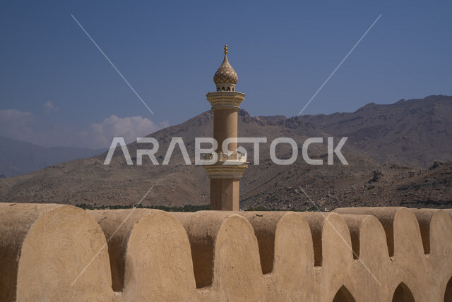 Close-up of the Nizwa Castle Mosque in the Sultanate of Oman, a flagpole, the flag of Oman, the historic Nizwa Castle, Oman's famous landmarks, architectural art, forts and castles, a mosque minaret, worship and getting closer to God, tourism in Oman