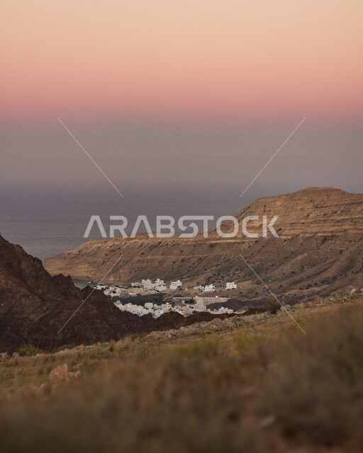 صورة للطبيعة الجبلية في المملكة العربية السعودية اثناء غروب الشمس، المنباني والبيوت السكنية، جمال السماء وقت الغروب، السياحة في السعودية