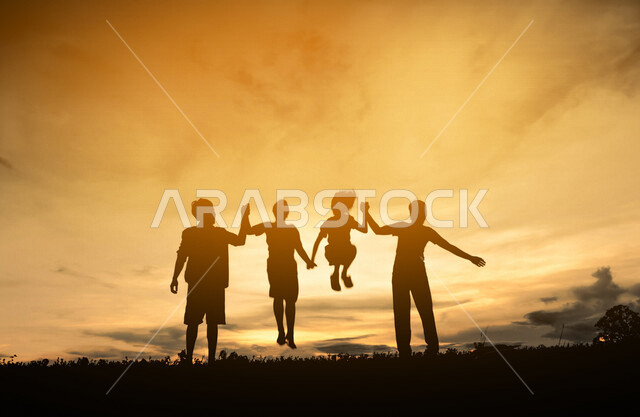 صورة ظلية لمجموعة من الاشخاص يقفزون للأعلى اثناء غروب الشمس، جمال الطبيعة، المرح والترفيه، صورة ظلية