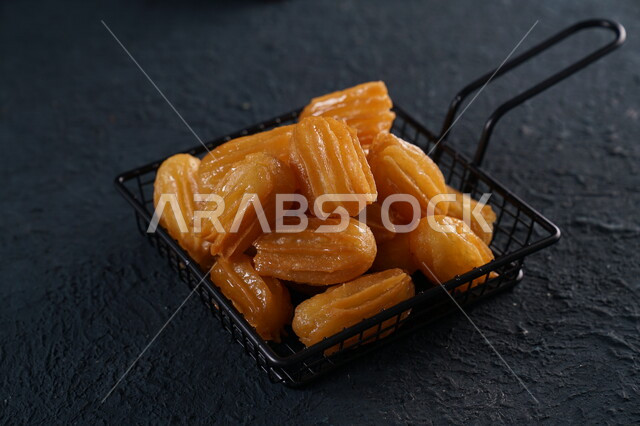 A plate of the famous ramadan hala balah sham, ramadan sweets, a popular sweet, delicious crunchy balah sham, black background