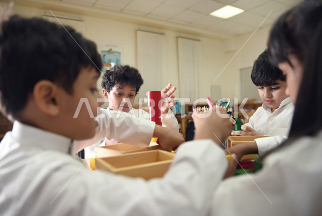 طلاب وطالبات المرحلة الإبتدائية يقومون بعمل نشاطات جماعية ترفيهية , متعة التعلم في الفصل , تعلم مهارات التركيز والابتكار للطلاب والطالبات في مدارس المملكة العربية السعودية .