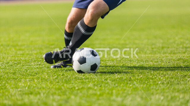 شاب في الملعب يمارس اللعب بكرة القدم ، لاعب كرة قدم، ممارسة رياضة كرة القدم، ملعب كرة قدم، ممارسة الرياضة، المراوغة وتسجيل الاهداف