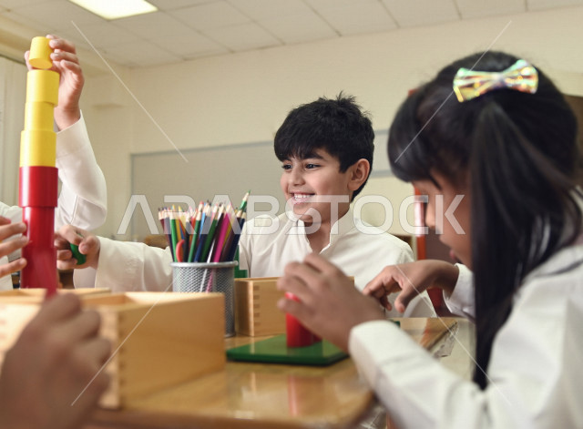 طلاب وطالبات المرحلة الإبتدائية يقومون بعمل نشاطات جماعية ترفيهية , متعة التعلم في الفصل , تعلم مهارات التركيز والابتكار للطلاب والطالبات في مدارس المملكة العربية السعودية .