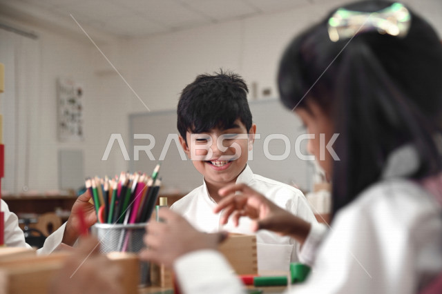 طلاب وطالبات المرحلة الإبتدائية يقومون بعمل نشاطات جماعية ترفيهية , متعة التعلم في الفصل , تعلم مهارات التركيز والابتكار للطلاب والطالبات في مدارس المملكة العربية السعودية .