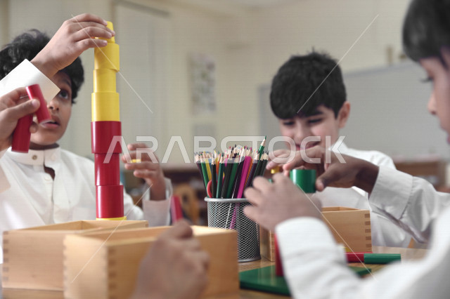 طلاب وطالبات المرحلة الإبتدائية يقومون بعمل نشاطات جماعية ترفيهية , متعة التعلم في الفصل , تعلم مهارات التركيز والابتكار للطلاب والطالبات في مدارس المملكة العربية السعودية .