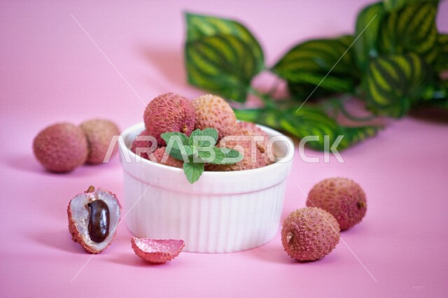 A plate of ripe lychee fruit, close-up of delicious lychee fruit, lychee leaf, healthy tropical fruit, colorful background
