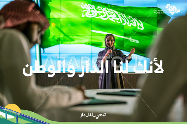 مرأة عربية خليجية سعودية تقف امام خلفية لعلم المملكة العربية السعودية، القاء كلمة ترحيبية في مؤتمر سعودي، هوية اليوم الوطني السعودي 92 ، رجل سعودي خليجي يدون الملاحظات، مؤتمرات وندوات في السعودية، شعار هي لنا دار، لأنك لنا الدار والوطن