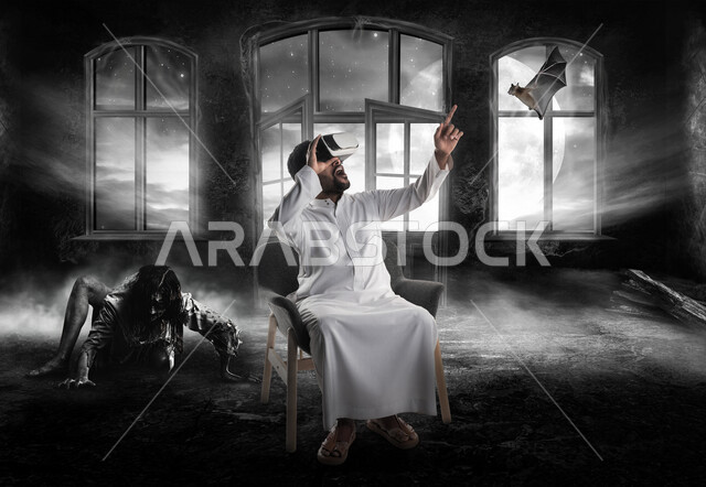 رجل عربي سعودي خليجي يجلس في غرفة يرتدي نظارة الواقع الإفتراضي ثلاثية الأبعاد, مشاهدة أفلام وألعاب الرعب , رسومات تعبر عن الرعب ، محاكاة العالم الافتراضي, تسليه وترفيه 
