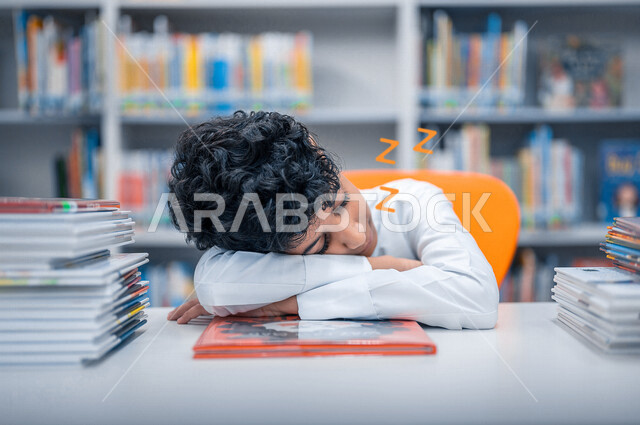 A Saudi Arabian Gulf student sleeping at a table in the school library, exhaustion from staying up late at night, studying late, diligently and diligently, self-learning, the background of the library.
