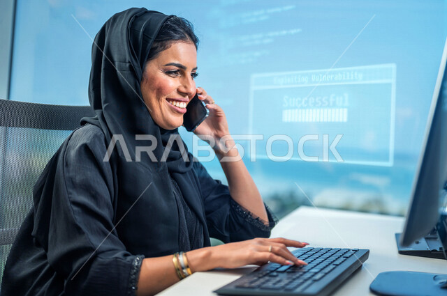 سيدة اعمال عربية خليجية سعودية تستخدم جهاز الحاسوب ، استخدام الهاتف النقال للتواصل مع الأصدقاء ، العمل داخل مقر الشركة ، انجاز مهام العمل ،تحقيق اهداف الشركة ، متابعة وتطوير العمل , رسومات بتقنية الهولوجرام .