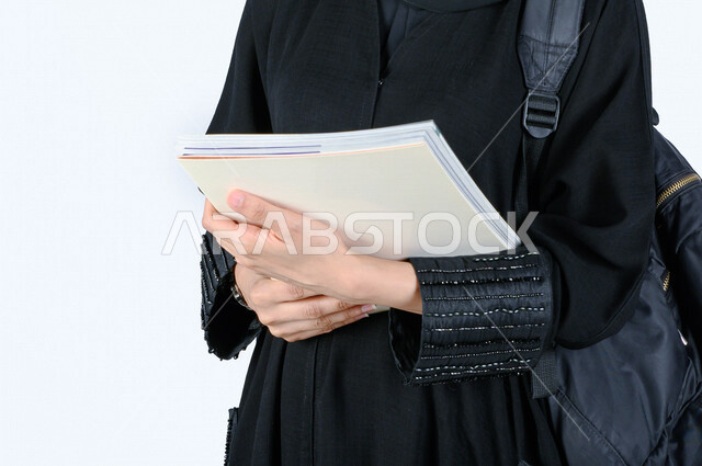 Portrait of a Saudi Arabian Gulf university student holding in her hand the university admission and registration file, preparing for the new academic year, a diligent student eager to go to university, schools and universities, education in Saudi Arabia,